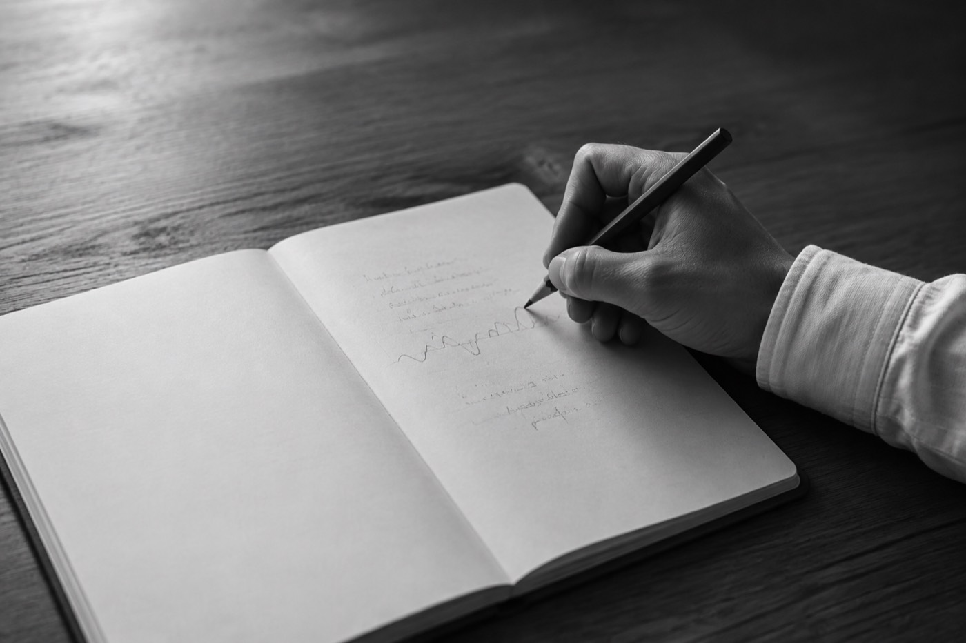 ノートに、これまでの経験と人生の浮き沈みを鉛筆で書き出している手元